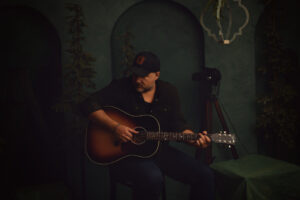 Steph Morin Christmas Press Picture 2 Green Background and acoustic guitar by Natacha Driscoll 2025